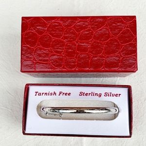 Silver bangle bracelet with latch and lock opening.